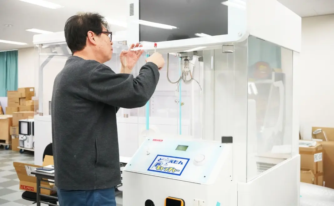プライズマシンの調整作業を行うスタッフの様子