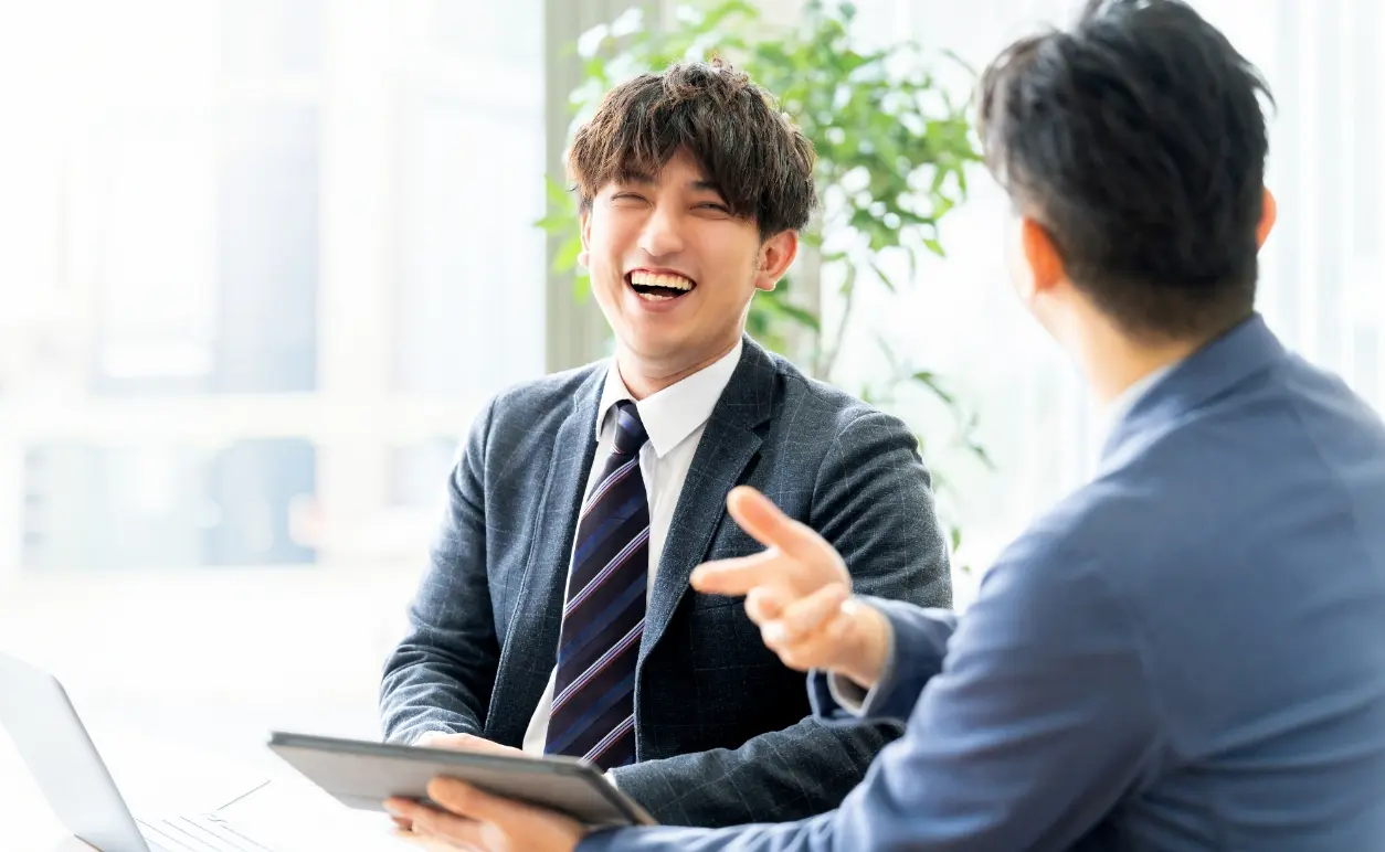 打ち合わせをしながら笑顔で会話するスタッフの様子